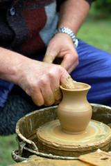 hands of a potter, creating an earthen jar on the circle