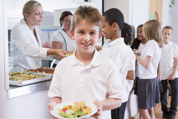 Wall Mural - Schoolboy holding plate of lunch in school cafeteria