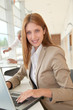 © goodluz - Smiling businesswoman in front of laptop
