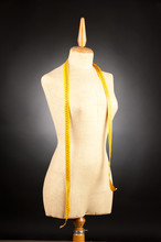 Tailor Mannequin With Tape Measure On Black Background