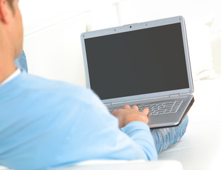 Wall Mural - man relaxing with his laptop on a couch