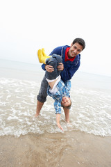 Happy father with son on beach