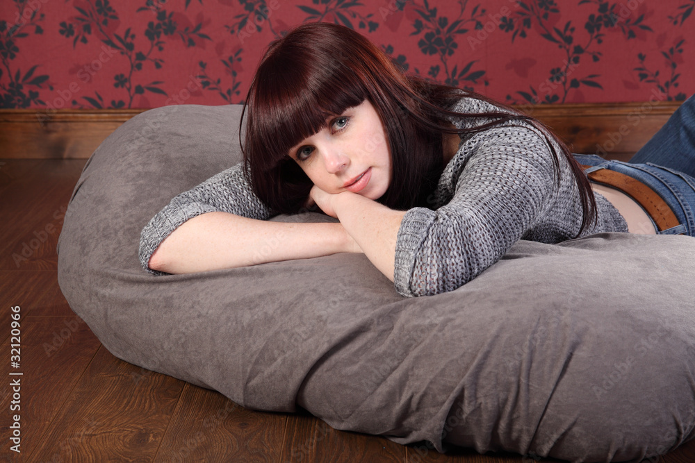Beautiful young woman relaxing on bean bag Stock Photo | Adobe Stock