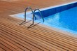 canvas print picture - blue swimming pool with teak wood flooring