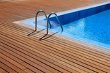 Fototapeta Miasta - blue swimming pool with teak wood flooring