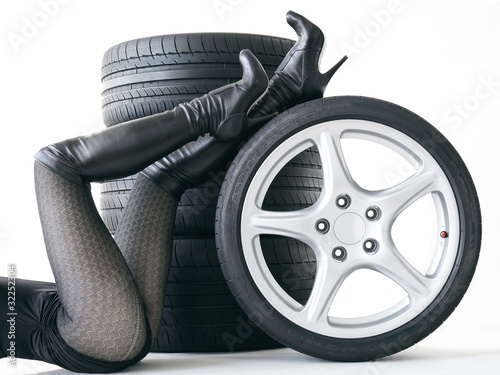 Naklejka ścienna Sexy woman with High Heels playing with set of summer tyres