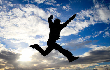 silhouette of man jumping in sky