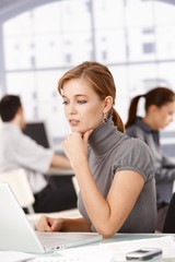 Wall Mural - Young office worker using laptop sitting at desk