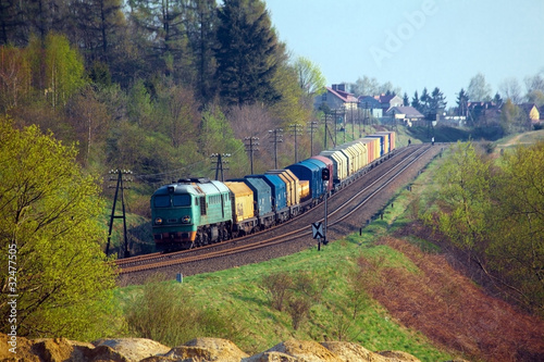 Obraz w ramie Freight train passing the hilly landscape