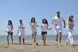 © .shock - happy people group have fun and running on beach