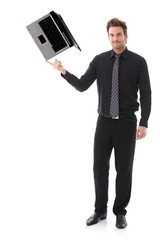 Poster - Young man balancing a laptop on his forefinger