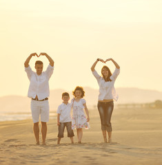 Wall Mural - happy young family have fun on beach at sunset