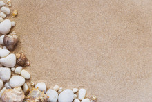 Sea Shells And Stones With Sand As Background