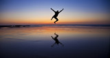 Fototapeta Fototapety z morzem do Twojej sypialni - Silhouette of a jumping man on the beach by the ocean