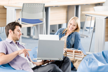 Wall Mural - Young students at high-school pointing at laptop