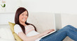 © WavebreakmediaMicro - Attractive red-haired woman relaxing with her laptop while lying