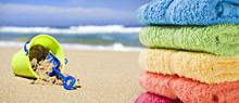 Colorful Towels On A Beach With Toy Bucket And Spade