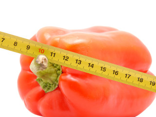 Pepper and ruler on a white background