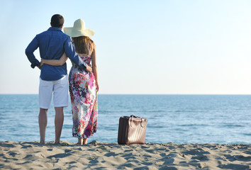 couple on beach with travel bag