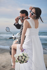 Wall Mural - just married couple on the beach ride white scooter