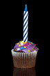 cupcake with candle over black background