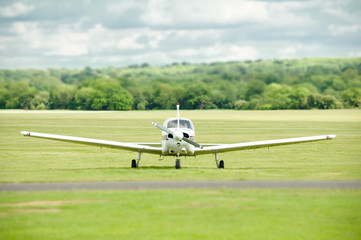 light aircraft on a grass airstrip with blurred background