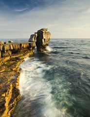 Wall Mural - Stunning geological rock cliff formations with waves crashing in