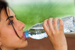 Mujer joven bebiendo agua de una botella