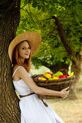 Sticker - Beautiful redhead girl with fruits in basket at garden.