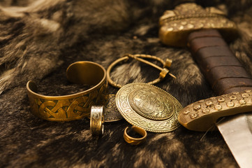 Still life with scandinavian jewels and sword on a fur