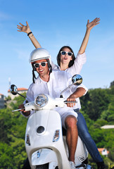 Wall Mural - Portrait of happy young love couple on scooter enjoying summer t