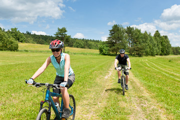 Sport couple riding mountain bicycles in coutryside