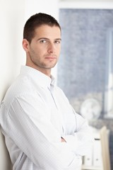 Canvas Print - Goodlooking man standing arms crossed