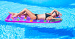 Woman with hat relaxing  on air mattress in the pool
