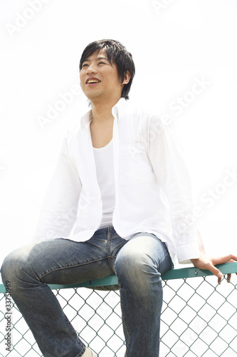 フェンスに座る男性 Stock Photo Adobe Stock