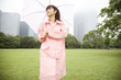 傘をさして公園を歩く女性
