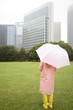 傘をさして公園に立つ女性の後姿