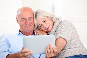 Wall Mural - Senior couple using electronic tablet at home
