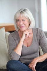 Sticker - Portrait of smiling senior woman sitting in sofa