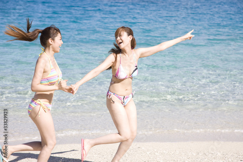 浜辺を駆ける水着を着た2人の女性 Stock Photo Adobe Stock