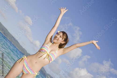 浜辺で万歳をしている水着姿の女性 Stock Photo Adobe Stock