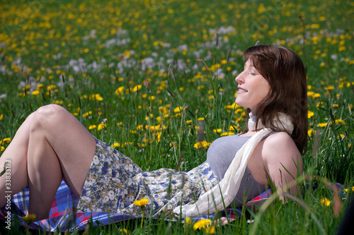 Junge Frau im Kleid genießt den Frühling auf der Wiese Junge Frau im Kleid genießt den Frühling auf der Wiese