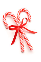 Closeup Of Candy Canes Tied With Ribbon Bow On White