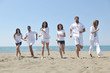 © .shock - happy people group have fun and running on beach