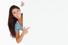 Smiling Woman Pointing At A Board