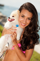 Wall Mural - Pretty young brunette woman with her Pomeranian puppy