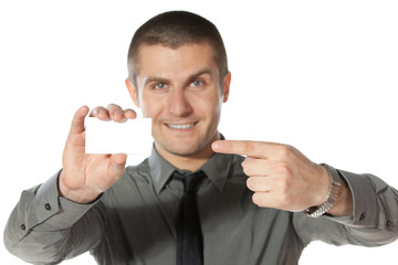 Young smiley business man pointing to the blank business card