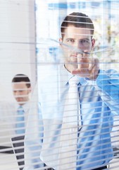 Canvas Print - Handsome businessman peeping through blind