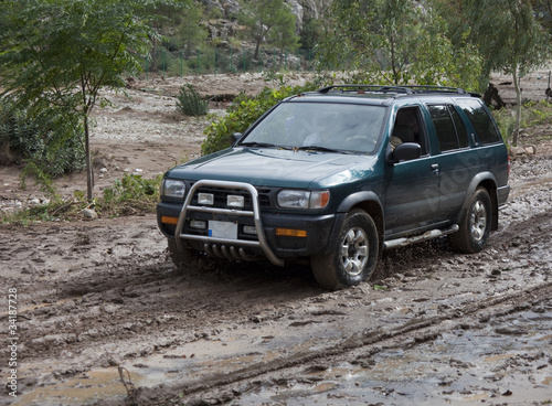 Naklejka ścienna Off-Road Vehicle driving on muddy Road