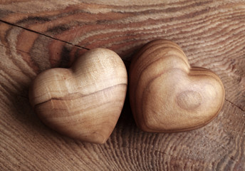 Two wooden hearts on brown background